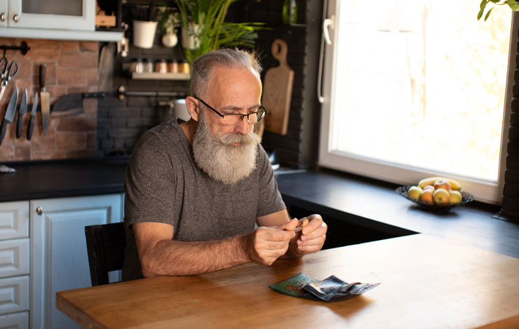 Older man rolling a joint
