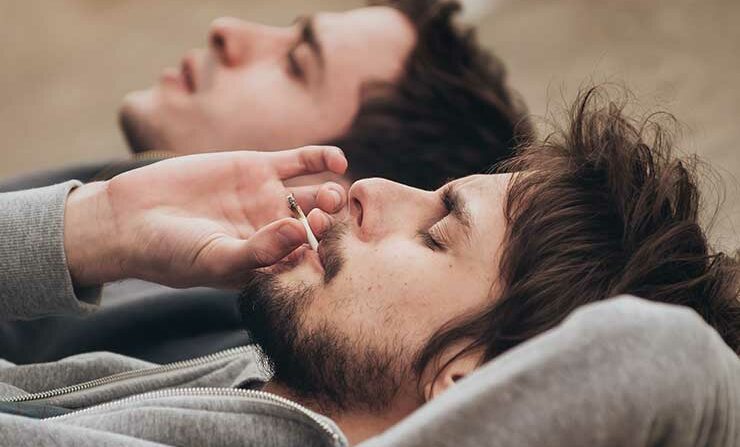 Two men smoking a joint