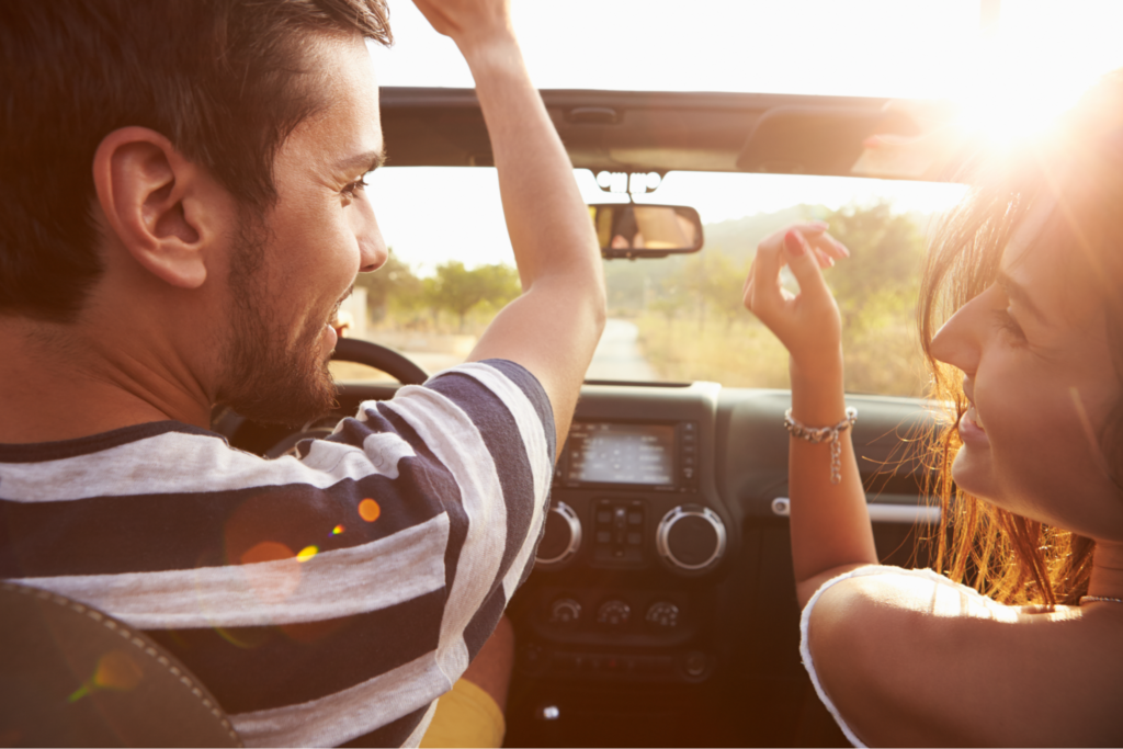 A young couple driving along a country road