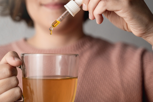 Woman using a cannabis tincture in tea