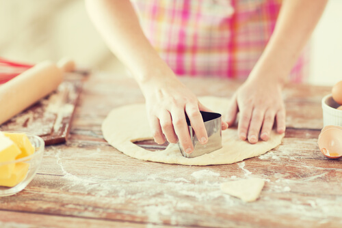 Hands making sugar cookies from fresh dough at home